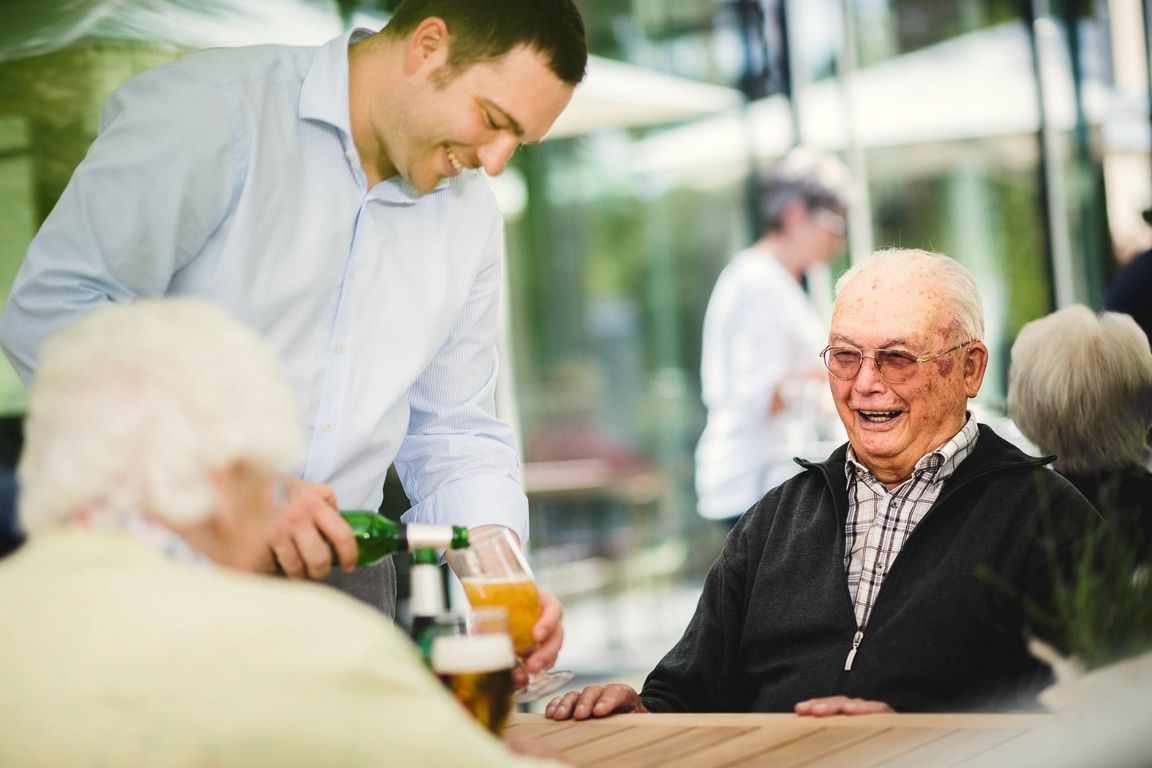 Terrasse Restaurant Mann bekommt Bier eingeschenkt Pflegeheim in Hannover Landhaus Pflege und Wohnen