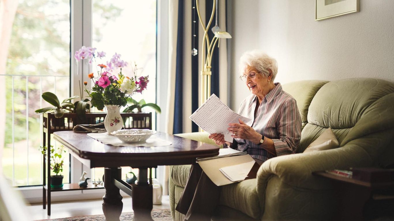 Pflegeheim Landhaus Pflege & Wohnen Einzelzimmer Bewohnerin liest Zeitung auf Sofa