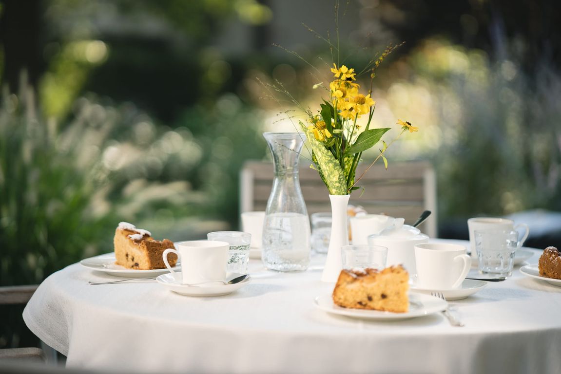 Gedeckter Tisch mit Blume in Vase, Kaffee und Kuchen im Pflegeheim in Hannover Landhaus Pflege und Wohnen