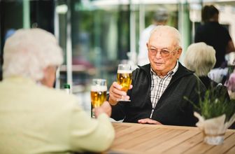Ehepaar stösst mit Bier an auf Terrasse im Pflegeheim in Hannover Landhaus Pflege und Wohnen
