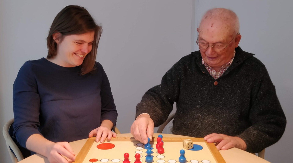 Ergotherapeutin Judith Franke spielt mit Bewohner Johannes Kühn Mensch ärger dich nicht im Pflegeheim Landhaus Pflege und Wohnen in Hannover
